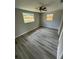 Spacious bedroom with wood-look flooring, ceiling fan, and large windows at 5038 Galaxy Dr, New Port Richey, FL 34652