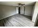 Spacious bedroom with wood-look flooring and access to other rooms at 5038 Galaxy Dr, New Port Richey, FL 34652