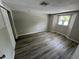 Empty bedroom with wood-look flooring and several windows at 5038 Galaxy Dr, New Port Richey, FL 34652