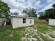 Exterior view of the house with a small yard and a storage shed at 5038 Galaxy Dr, New Port Richey, FL 34652