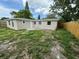 Exterior view of a single-story home with a fenced backyard and grassy area at 5038 Galaxy Dr, New Port Richey, FL 34652