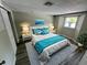Comfortable bedroom featuring a queen bed, soft gray carpet, and tasteful turquoise accents at 5038 Galaxy Dr, New Port Richey, FL 34652