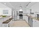 Modern white kitchen with stainless steel appliances, granite countertops, and breakfast bar at 5130 Brittany S Dr # 505, St Petersburg, FL 33715