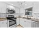White kitchen with granite countertops, stainless steel appliances, and a window over the sink at 5130 Brittany S Dr # 505, St Petersburg, FL 33715