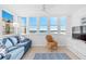 Comfortable living room with waterfront views, blue couch, wicker chair, and TV at 5130 Brittany S Dr # 505, St Petersburg, FL 33715