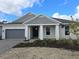 Charming single-Gathering home with a gray garage door, white columns, and landscaping at 1588 Laurel Brook Ln, Port Charlotte, FL 33953