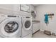 Laundry room with Whirlpool washer and dryer, counter, and wall hooks at 16018 10Th E Ave, Bradenton, FL 34212