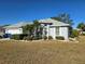 One-story home with two-car garage, landscaped yard with palm tree, and light gray exterior at 1705 S Pebble Beach Blvd, Sun City Center, FL 33573