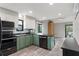 Modern kitchen featuring stylish green cabinets, black countertops, and stainless steel appliances at 203 Lagoon Dr, Palm Harbor, FL 34683