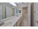 Spacious bathroom featuring dual sinks, large mirror, and a walk-in tub at 2701 Lancaster Dr, Sun City Center, FL 33573