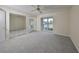 Carpeted bedroom with a large window, mirrored closet doors, and neutral walls at 2701 Lancaster Dr, Sun City Center, FL 33573