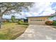 House with blue tarp and attached garage at 2701 Lancaster Dr, Sun City Center, FL 33573