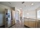 Kitchen with stainless steel refrigerator, white cabinetry, and granite countertops at 2701 Lancaster Dr, Sun City Center, FL 33573