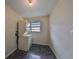 Laundry room with stacked washer and dryer, dark tile flooring and window at 2701 Lancaster Dr, Sun City Center, FL 33573