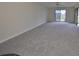 Living room with sliding doors to the backyard, gray carpet, and neutral walls at 2701 Lancaster Dr, Sun City Center, FL 33573