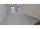 Spacious living room with gray carpet and sliding glass doors leading to the backyard at 2701 Lancaster Dr, Sun City Center, FL 33573