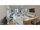 Living room with white wicker furniture, blue accents, and large windows at 2701 Lancaster Dr, Sun City Center, FL 33573
