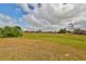 Open field with green grass under a cloudy blue sky at 2701 Lancaster Dr, Sun City Center, FL 33573