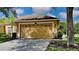 Tan house with two-car garage and landscaped yard at 4247 Ashton Meadows Way, Wesley Chapel, FL 33543