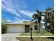 Charming single-Gathering home featuring a manicured lawn, paver driveway and tropical landscaping at 442 Bahama Grande Blvd, Apollo Beach, FL 33572