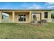 House exterior with covered patio, AC unit, and grassy yard at 442 Bahama Grande Blvd, Apollo Beach, FL 33572