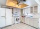 Bright kitchen with white cabinetry and appliances, a ceiling fan, and tiled flooring at 5316 Buttonwood Dr, New Port Richey, FL 34652