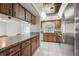 Long view of a kitchen with wood cabinets, stainless steel appliances, and tile floor at 6168 Applegate Dr, Spring Hill, FL 34606