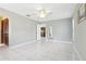 Bright living area with tile floors, a view into kitchen, and ceiling fan at 6168 Applegate Dr, Spring Hill, FL 34606