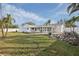Backyard with covered patio, lush green lawn, rock pond, and palm trees at 6459 30Th N Ave, St Petersburg, FL 33710