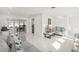Living room with white tile flooring, gray couches, and a view into the dining area at 6459 30Th N Ave, St Petersburg, FL 33710