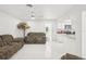 Open living room with view of kitchen, white tile, brown couches, and ceiling fan at 6459 30Th N Ave, St Petersburg, FL 33710