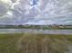 Community pond and green space behind a row of houses under a cloudy sky at 8379 Ender Hills Dr, Wesley Chapel, FL 33545