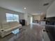 Living room with white sofa, entertainment center, and tile flooring at 8379 Ender Hills Dr, Wesley Chapel, FL 33545
