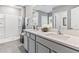 Modern bathroom featuring a double vanity with gray cabinets and a walk-in shower at 10543 Dusty Boot Rd, Land O Lakes, FL 34638