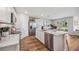 Modern kitchen with white cabinets, stainless steel appliances, and an island with marble countertops at 10903 Gentle Current Way, Parrish, FL 34219