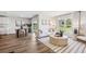 Open living room with modern decor, wood floors, and large windows for ample natural light at 10903 Gentle Current Way, Parrish, FL 34219