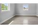 Empty bedroom with light gray walls, wood-look tile, and abundant natural light at 13122 4Th E St, Madeira Beach, FL 33708