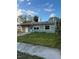 Green house with a two-car garage and carport at 1787 Shore Acres Ne Blvd, St Petersburg, FL 33703