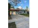 Ranch-style house with a green exterior, driveway, and lawn at 1787 Shore Acres Ne Blvd, St Petersburg, FL 33703