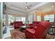 Spacious living room with red leather furniture and a view of the golf course at 1847 Pacific Dunes Dr, Sun City Center, FL 33573