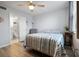 Bedroom with a striped comforter, ceiling fan, and adjacent bathroom at 1945 Pelican Landing Blvd # 616, Clearwater, FL 33762