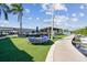 A waterfront dock area with outdoor seating, palm trees, and boat slips on a sunny day at 2700 Cove Cay Dr # 2F, Clearwater, FL 33760