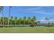 Scenic golf course view with palm trees, a wooden bridge, and golf carts at 2700 Cove Cay Dr # 2F, Clearwater, FL 33760
