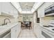 Bright kitchen featuring white cabinetry, modern appliances, and a cozy breakfast nook with views outside at 2700 Cove Cay Dr # 2F, Clearwater, FL 33760