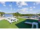 Lawn area with picnic tables next to a dock and waterfront view, under a blue sky with fluffy white clouds at 2700 Cove Cay Dr # 2F, Clearwater, FL 33760