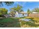 Fenced backyard with detached garage, grassy area, and paved patio at 323 W Hanna Ave, Tampa, FL 33604