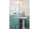 Bathroom with teal tile, pedestal sink, and window with blinds at 323 W Hanna Ave, Tampa, FL 33604