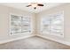 Empty bedroom with neutral walls, carpeted floors, and multiple windows at 323 W Hanna Ave, Tampa, FL 33604