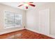 Empty bedroom with neutral walls, wood-look floors, ceiling fan, and window at 323 W Hanna Ave, Tampa, FL 33604