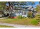 Charming light blue bungalow home with front porch and green lawn at 323 W Hanna Ave, Tampa, FL 33604